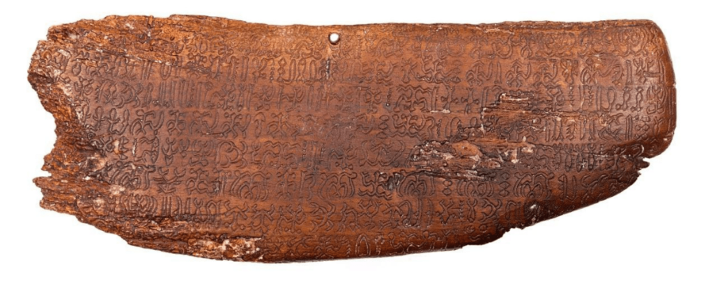 Color photo of a worn wooden tablet engraved with intricate Rongorongo characters.