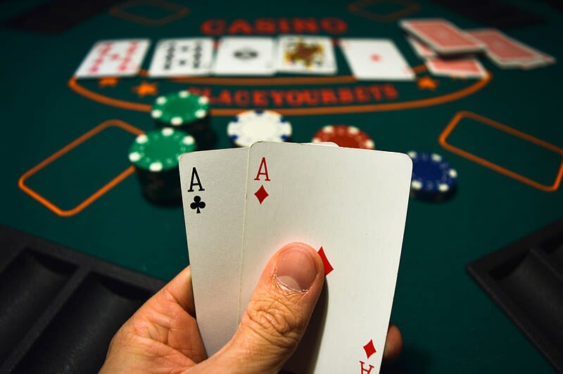 A player holding their pocket cards and in the back the five community cards
on the table.