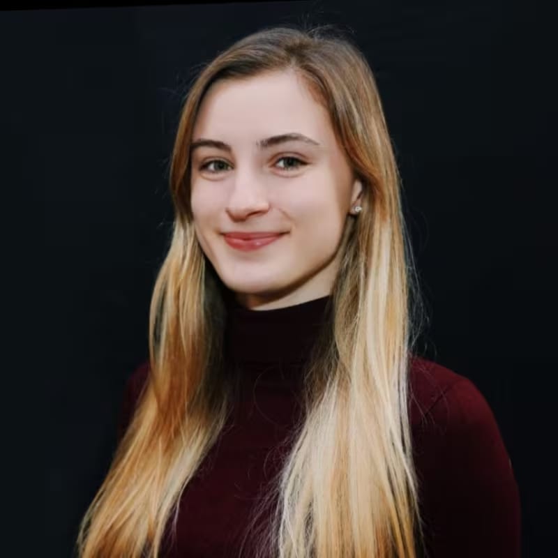 A blonde woman smiles confidently.